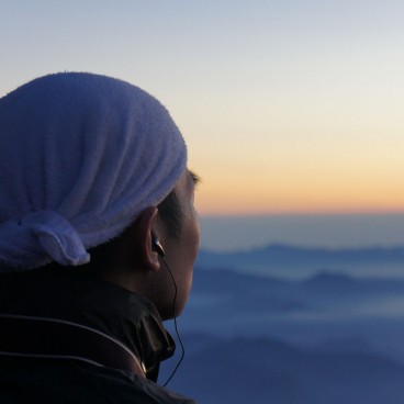 A successfull climber contemplating the scenery at the top of Mount Fuji