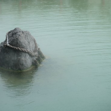 Jigoku Meguri in Beppu, Shimenawa stone in the pond at Kamado-jigoku