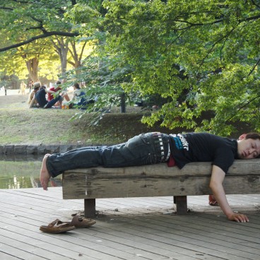 Yoyogi Park in Tokyo, Man asleep on a wooden bench