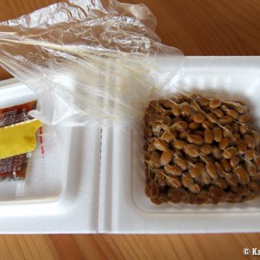 An opened pack of natto, with soybeans and toppings