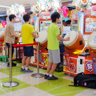 Young Japanese playing musical games at the arcade (Game Center) in Tokyo