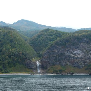 Shiretoko (Hokkaido), View on Kamuiwakka Falls and cloudy Mount Io from the cruise departing from Utoro Port