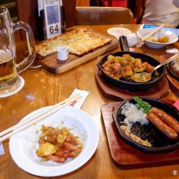 Ginza Lion 7-Chome (Tokyo), Dish selection (sausages, potato curry, flammekueche) and Sapporo beer